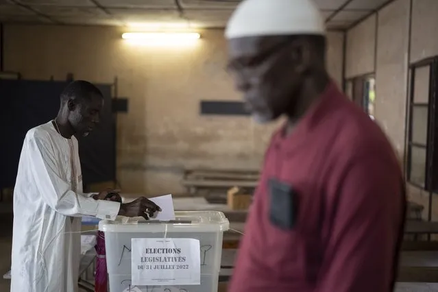 A man casts his vote for legislative elections, at a polling station in Dakar, Senegal, Sunday, July 31, 2022. The West African nation is holding legislative elections, a vital test for opposition parties trying to minimize ruling party influence before 2024 presidential elections amid worries President Macky Sall may seek a third term. (Photo by Leo Correa/AP Photo)