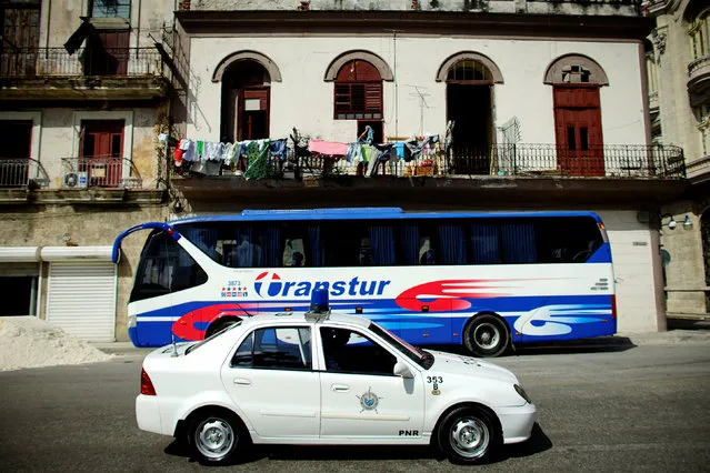 A Chinese-made Geely police car passes by a parked Yutong bus, which is also made in China, in Havana, Cuba, February 10, 2017. (Photo by Alexandre Meneghini/Reuters)