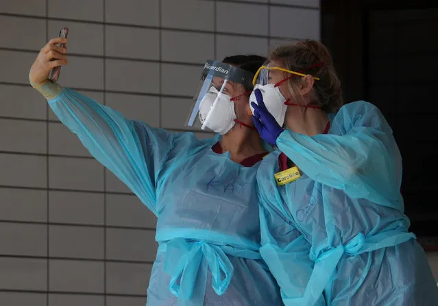 Medical staff wearing protective clothing take a selfie at St Thomas' hospital as the spread of the coronavirus disease (COVID-19) continues, London, Britain, March 31, 2020. (Photo by Hannah McKay/Reuters)