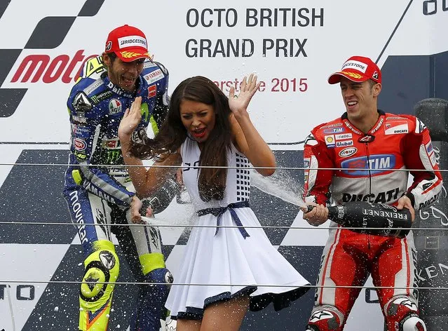 Winning Yamaha MotoGP rider Valentino Rossi of Italy (L) and third placed Ducati MotoGP rider Andrea Dovizioso of Italy spray a grid girl after the British Grand Prix at the Silverstone Race Circuit, Britain August 30, 2015. (Photo by Darren Staples/Reuters)