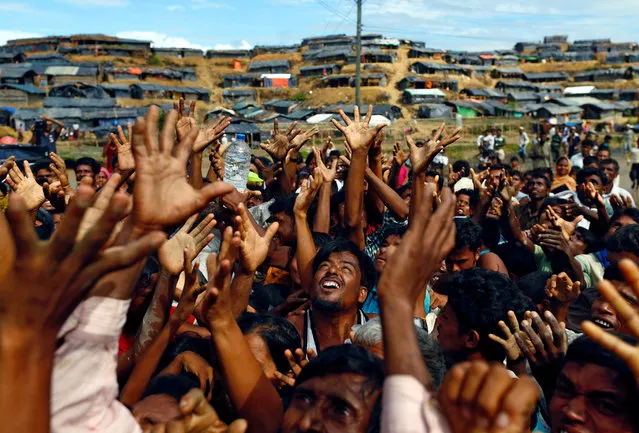 Rohingya refugees stretch their hands to receive aid distributed by local organisations at Balukhali makeshift refugee camp in Cox's Bazar, Bangladesh, September 14, 2017. (Photo by Danish Siddiqui/Reuters)