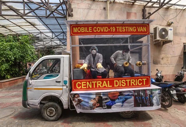 Health care workers take samples from patients at a mobil COVID-19 antibody rapid testing van during the Coronavirus outbreak in New Delhi, India on April 21, 2020. (Photo by Biplov Bhuyan/Hindustan Times/Rex Features/Shutterstock)