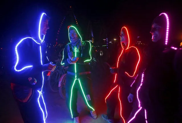 A group of participants wear illuminated suits during the Burning Man 2015 “Carnival of Mirrors” arts and music festival in the Black Rock Desert of Nevada, September 5, 2015. Approximately 70,000 people have come to the sold-out festival that Sunday evening. (Photo by Jim Urquhart/Reuters)