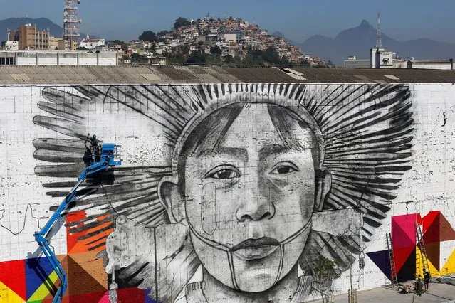 Graffiti artists work on a wall as they create a massive mural on Rio's Olympic Boulevard featuring native people from five continents ahead of the Rio 2016 Olympic Games in Rio de Janeiro, Brazil July 14, 2016. (Photo by Bruno Kelly/Reuters)