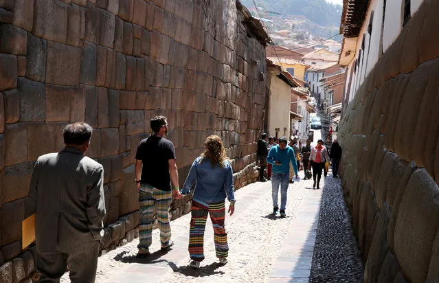 Tourists visit an Inca wall at a street in down town Cuzco, Peru, October 5, 2017. (Photo by Mariana Bazo/Reuters)