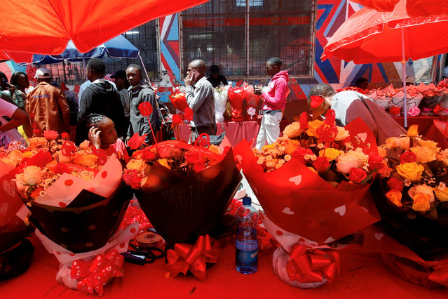 People walk past bouquets displayed for sale to mark Valentine's Day celebrations in Nairobi, Kenya, on February 14, 2025. (Photo by Monicah Mwangi/Reuters)