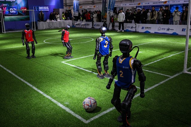 Robots from Booster Robotics play football during the Global Developer Conference, organised by the Shanghai AI Industry Association, in Shanghai on February 21, 2025. (Photo by Hector Retamal/AFP Photo)
