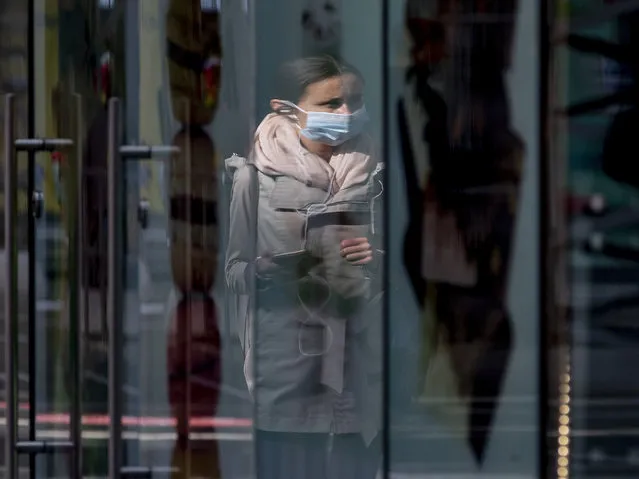 A woman wearing a face mask is reflected in a shop window at the central train station in Frankfurt, Germany, Thursday, June 18, 2020. (Photo by Michael Probst/AP Photo)