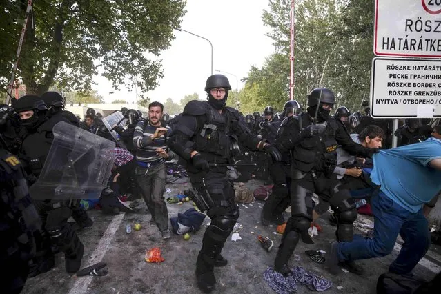 Hungarian riot police fight migrants at the border crossing with Serbia in Roszke, Hungary September 16, 2015. (Photo by Marko Djurica/Reuters)