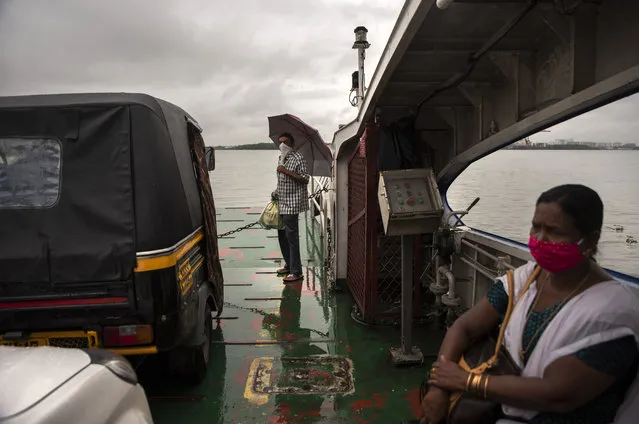 Commuters wearing masks as a precaution against the coronavirus travel in a ferry during rain in Kochi, Kerala state, India, Monday, June 22 2020. India is the fourth hardest-hit country by the COVID-19 pandemic in the world after the U.S., Russia and Brazil. (Photo by R.S. Iyer/AP Photo)