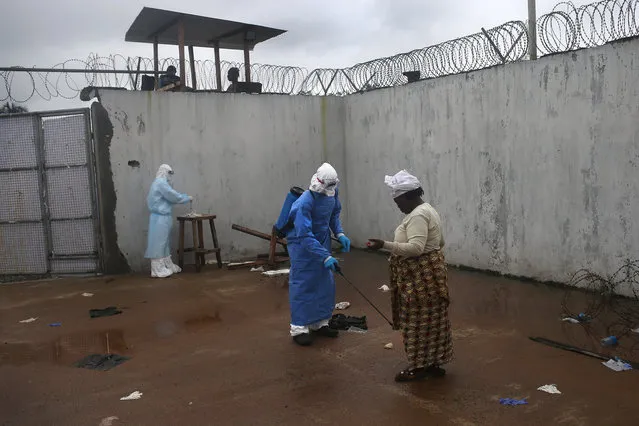 A family member is disinfected after bringing a sick relative to the Ebola treatment center at the Island Hospital on October 6, 2014 on the outskirts of Monrovia, Liberia. The hospital, with it's 120 beds, has remained at capacity since it's opening by the Liberian Ministry of Health and the World Health Organization (WHO), in September. The Ebola outbreak has killed more than 3,400 people in West Africa, according to the WHO. (Photo by John Moore/Getty Images)