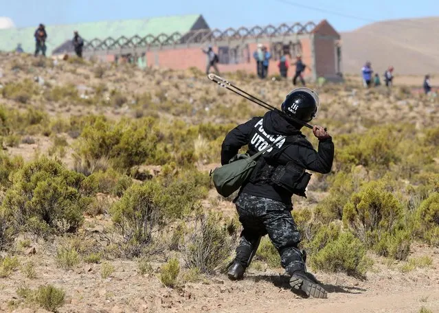 Bolivian policemen clash with miners near a blocked road in Panduro, Bolivia, 25 August 2016. The miners, the majority of whom are members of the National Federation of Mining Cooperatives of Bolivia (FENCOMIN) organized the indefinite strike to demand amendments to the Mining Act, as well as improvements in working conditions and pay, among other concessions. According to media reports, there has been at least one casualty during the clashes, as Bolivian Deputy Interior Minister Rodolfo Illanes was allegedly beaten to death by a group of mineworkers. (Photo by Martin Alipaz/EFE)