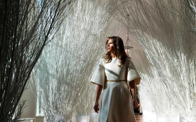 US First Lady Melania Trump walks through Christmas decorations in the East Wing as she tours holiday decorations at the White House in Washington, DC, on November 27, 2017. (Photo by Saul Loeb/AFP Photo)