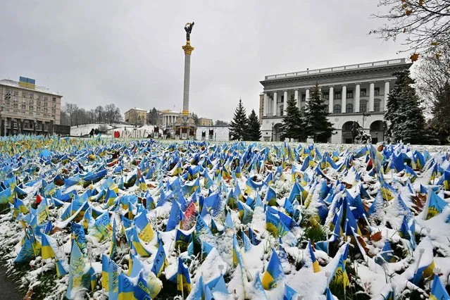 This photograph taken on November 17, 2022, shows Ukrainian flags set at Independence Square in Kyiv, symbolizing the deaths of Ukrainian soldiers in the conflict, covered with snow after the first snow falls of the season, amid the Russian invasion of Ukraine. (Photo by Sergei Supinsky/AFP Photo)