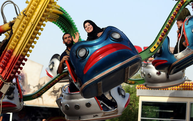 Iraqis enjoy a ride at Amusement City fairgrounds during Eid al-Adha celebrations in Baghdad, Iraq, Friday, September 25, 2015. Eid al-Adha, or Feast of Sacrifice, commemorates what Muslims believe was Prophet Abraham's willingness to sacrifice his son. It is a festive holiday where it is traditional for men, women and children to dress in new clothing and spend time with their families outdoors. (Photo by Hadi Mizban/AP Photo)