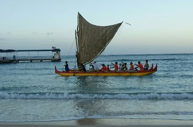 A traditional double-hulled canoe known as a vaka makes its way to shore at Waikiki Beach in Honolulu on September 1, 2016. Native Hawaiians and conservationists rowed the boat to symbolize respect for their ancestors and environmental stewardship at the start of the International Union for the Conservation of Nature's World Conservation Congress, the world's largest conservation gathering, being held in Honolulu September 1-10. (Photo by Kerry Sheridan/AFP Photo)