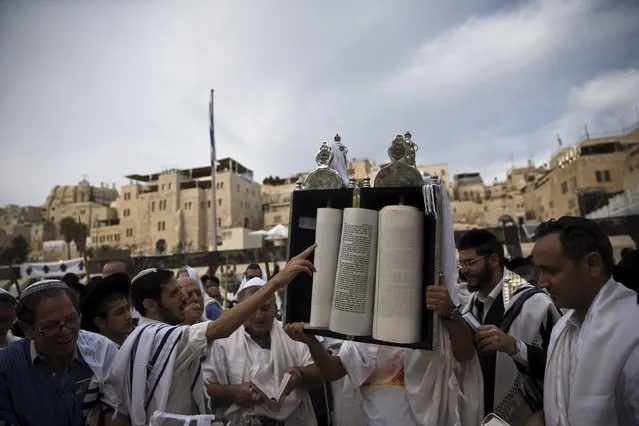 A Jewish worshipper holds up a Torah scroll before the recitation of the priestly blessing at the Western Wall, Judaism's holiest prayer site, during the holiday of Sukkot in Jerusalem's Old City September 30, 2015. (Photo by Ronen Zvulun/Reuters)