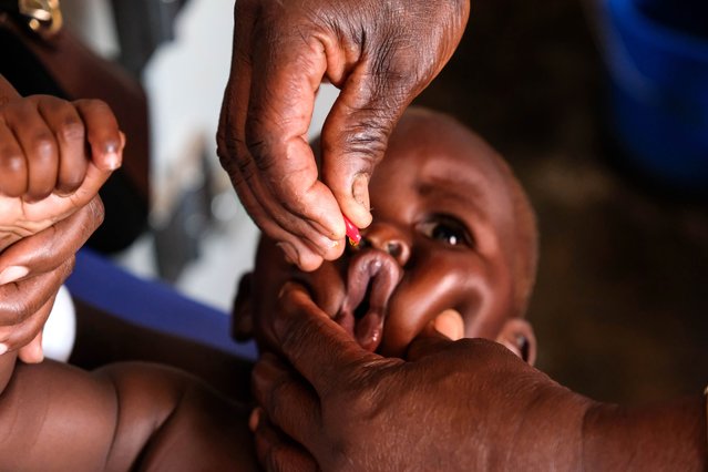 A nurse giving a baby vitamin A dose during malaria vaccination day at Apac General Hospital on April 8, 2025 in Apac District, Uganda. Uganda's Ministry of Health has begun the rollout of a massive malaria vaccine campaign that is expected to prevent at least 800 severe cases of malaria among children daily, with an initial target of vaccinating 1.1 million children under the age of two in the most affected districts of the East African nation. The R21/Matrix-M malaria vaccine is administered over four doses at 6, 7, 8, and 18 months and will be integrated into routine immunizations for young children, for whom the mosquito-transmitted disease is the leading cause of illness and death in Uganda. (Photo by Hajarah Nalwadda/Getty Images)