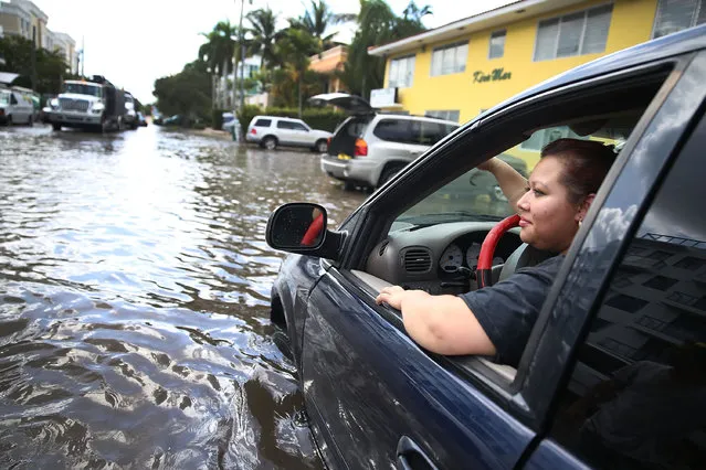 Sandy Garcia sits in her vehicle that was stuck in a flooded street caused by the combination of the lunar orbit which caused seasonal high tides and what many believe is the rising sea levels due to climate change on September 30, 2015 in Fort Lauderdale, Florida.  South Florida is projected to continue to feel the effects of climate change and many of the cities have begun programs such as installing pumps or building up sea walls to try and combat the rising oceans. (Photo by Joe Raedle/Getty Images)