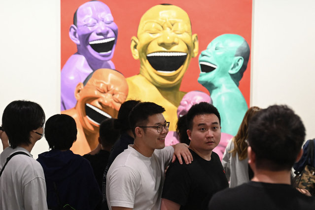 Visitors look at works by Chinese artist Yue Minjun on display at the Art Basel international art fair in Hong Kong on March 28, 2025. (Photo by Peter Parks/AFP Photo)