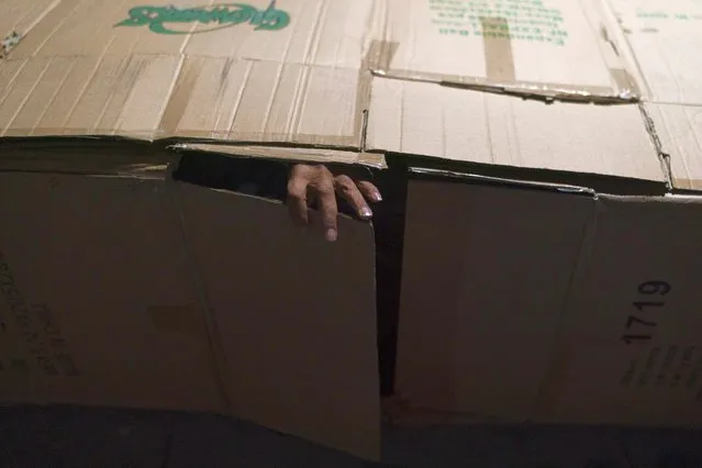 David Hernandez, a 62-year-old homeless man, shuts the flap after crawling into his makeshift bed made with cardboard boxes, Wednesday, December 14, 2022, in Los Angeles. Los Angeles Mayor Karen Bass declared a state of emergency Monday to grapple with the city's out-of-control homeless crisis, bidding to move swiftly to get thousands of unhoused people off her city's streets. (Photo by Jae C. Hong/AP Photo)