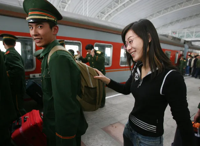 A Chinese veteran bids farewell to his girl friend after completing his military service before boarding a train back home in Nanjing of Jiangsu Province, China. (Photo by China Photos)