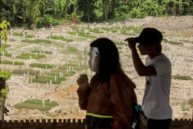 Relatives pay a visit to the cemetary where the victims of the COVID-19 pandemic are burried in Medan, North Sumatra, Indonesia, 26 August​ 2020. Indonesia has recorded over 160,000 cases of COVID-19. (Photo by Dedi Sinuhaji/EPA/EFE)