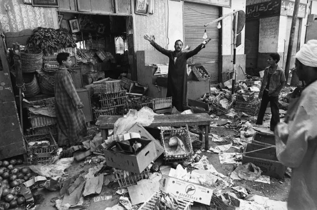 Shopkeeper in the Egyptian city of Asyut raises his arms in exasperation on October 9, 1981, after he said police looted his wares in the wake of a 24-hours gun battle between police, aided by the army, and Islamic extremists. (Photo by AP Photo/JJ)