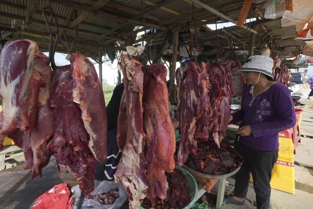 A villager buys beef at the roadside outside Phnom Penh Cambodia, Saturday, November 16, 2024. (Photo by Heng Sinith/AP Photo)