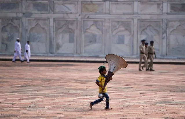An Indian Muslim boy runs as he holds a speaker during the Eid al-Adha festival at the mosque inside the Taj Mahal in Agra on September 13, 2016. Muslims across the world celebrate the annual festival of Eid al-Adha, or the Festival of Sacrifice, which marks the end of the Hajj pilgrimage to Mecca and in commemoration of Prophet Abraham's readiness to sacrifice his son to show obedience to God. (Photo by Chandan Khanna/AFP Photo)