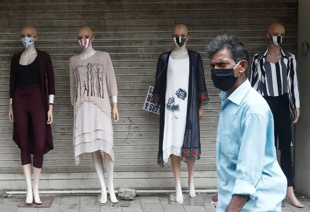 A man wearing a protective mask walks past mannequins on a street amidst the spread of the coronavirus disease (COVID-19) in Mumbai, India, September 12, 2020. (Photo by Francis Mascarenhas/Reuters)
