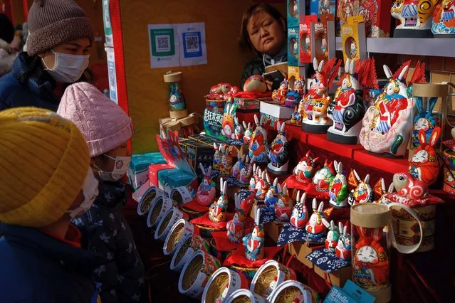 People look at rabbit figurines during Chinese New Year in Ditan Park, Beijing, China, 22 January 2023. The Chinese lunar new year, also called “Spring Festival”, falls on 22 January 2023, marking the beginning of the Year of the Rabbit. (Photo by Mark R. Cristino/EPA/EFE)