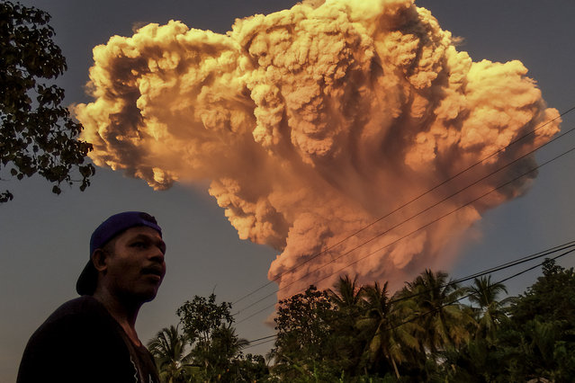 A villager watches the eruption of Mount Lewotobi Laki-Laki as seen from Talibura village in Sikka, East Nusa Tenggara, on June 17, 2025. A volcano in eastern Indonesia spewed a colossal ash tower into the sky on June 17, authorities said, after they raised its alert level to the highest of a four-tiered system. (Photo by AFP Photo/Stringer)