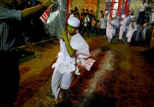 A Shi'ite Muslim walks on hot coals at a ceremony during the Ashura festival at a mosque in central Yangon October 21, 2015. Ashura is the most important day in the Shi'ite calendar, which commemorates the death of Imam Hussein, grandson of the Prophet Mohammad, in the 7th century battle of Kerbala. (Photo by Soe Zeya Tun/Reuters)