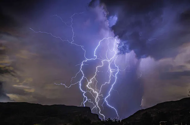 In this photo provided by Dakota Snider, a thunderstorm is seen from Highway 159 over Las Vegas on Thursday, August 11, 2022. A summer monsoon thunderstorm season unseen in Las Vegas in the last 10 years brought lightning and heavy rain to some areas late Thursday, and ceiling leaks that soaked playing cards and gambling at some Strip casinos. No injuries were reported, and damage estimates were not immediately provided as Friday dawned sunny and clear. (Photo by Dakota Snider via AP Photo)