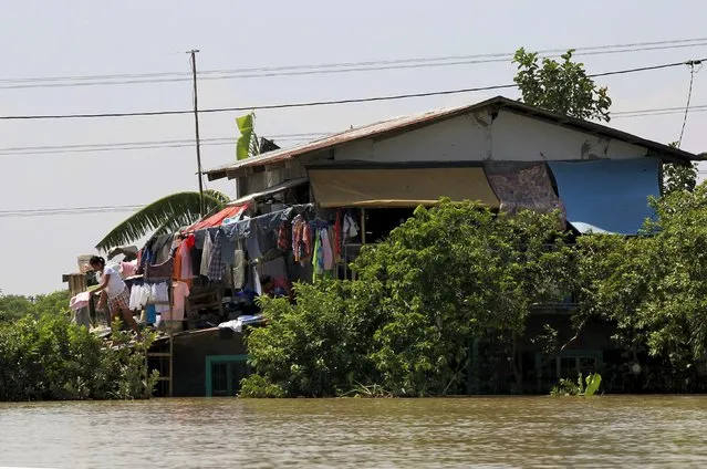 A resident takes their dry clothes while they house were submerged by floodwaters after a week typhoon Koppu battered Calumpit town, Bulacan province, north of Manila October 24, 2015. (Photo by Romeo Ranoco/Reuters)