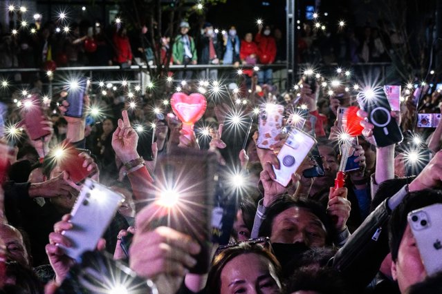 Supporters raise their phone torches during a campaign rally for South Korea's ruling People Power Party (PPP), on the eve of the parliamentary elections in Seoul on April 9, 2024. (Photo by Anthony Wallace/AFP Photo)