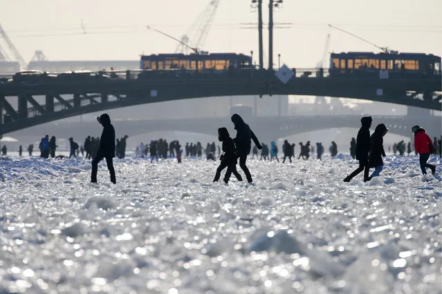 People walk on the frozen Neva River in central St Petersburg, Russia on March 4, 2018. (Photo by Peter Kovalev/TASS)
