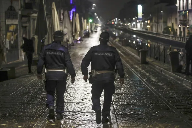 Two city police officers patrol the Navigli area, a popular evening spot of restaurants and pubs bordering canals in Milan, Italy, Thursday, October 22, 2020. Authorities in regions including Italy's three largest cities have imposed curfews in a bid to slow the spread of COVID-19, as many of the cases in Lombardy's surging outbreak have occurred in Milan. On Thursday, an overnight curfew takes effect in the city, known for its lively night-time bar scene, and the rest of the region, as authorities try to slow the spread of the contagion. (Photo by Luca Bruno/AP Photo)