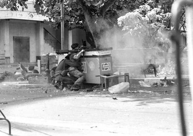 In this October 6, 1976, file photo, police fire a shell as they storm the walls of Thammasat University in Bangkok, Thailand. (Photo by Neal Ulevich/AP Photo)