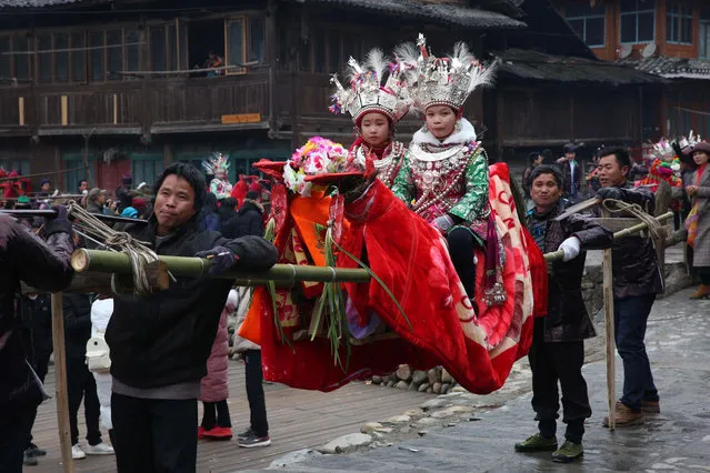 Dong children take part in a Taiguanren Festival (“Carrying the Governors Parade” in Chinese) to wish for favorable climatic weather in the new year at Liping County on February 22, 2018 in Qiandongnan Miao and Dong Autonomous Prefecture, Guizhou Province of China. “Taiguanren” is a folk custom of Dong people in which children or guests dressed up are carried by people to patrol around the village. (Photo by VCG/VCG via Getty Images)