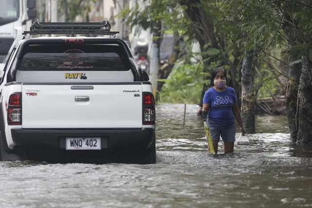 A resident negotiates a flooded road due to Typhoon Molave in Pampanga province, northern Philippines on Monday, October 26, 2020. A fast moving typhoon has forced thousands of villagers to flee to safety in provinces. (Photo by Aaron Favila/AP Photo)