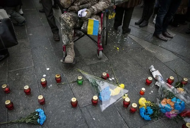 Servicemen of “Kiev 12” military defence battalion light candles to honour the memory of their dead comrades after a welcoming ceremony in central Ukrainian capital Kiev December 6, 2014. (Photo by Gleb Garanich/Reuters)