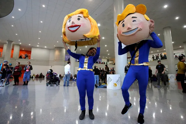 Vanessa Pham and Adrian Chan remove their costumes of Vault Boy and Vault Girl at New York Comic Con in Manhattan, New York, U.S., October 7, 2016. (Photo by Andrew Kelly/Reuters)