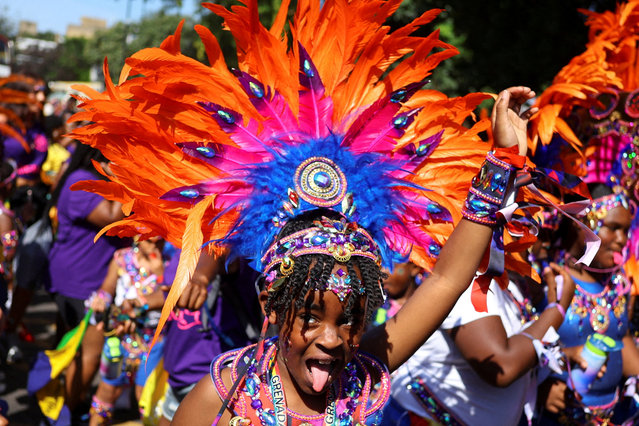 A child, wearing a headdress, gestures at the Children's Day Parade, during Notting Hill Carnival, in London, Britain on August 24, 2025. (Photo by Toby Melville/Reuters)