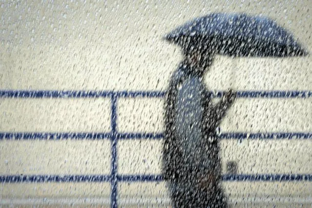 A person shelters from the rain on Wednesday, January 4, 2023, in Los Angeles. (Photo by Sarah Reingewirtz/The Orange County Register via AP Photo)