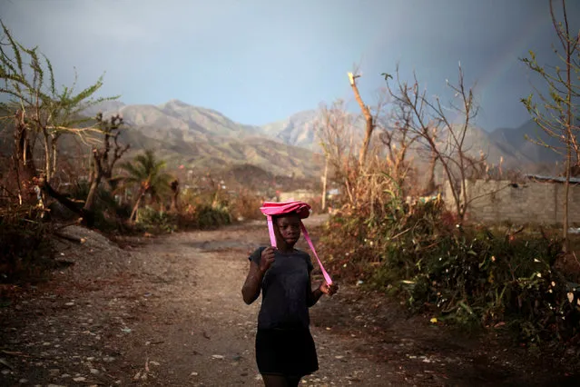 A girl protects herself from rain with a bag after Hurricane Matthew in Les Anglais, Haiti, October 13, 2016. (Photo by Andres Martinez Casares/Reuters)