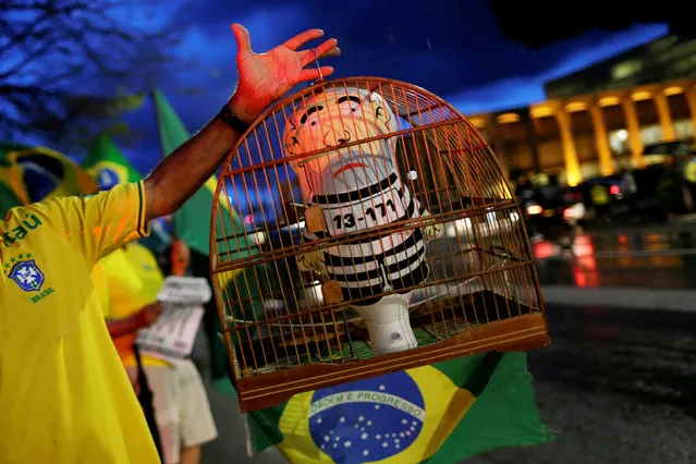 A demonstrator shows a doll depicting the former Brazilian President Luiz Inacio Lula da Silva in jail during a protest against Lula da Silva in Brasilia, Brazil, April 3, 2018. (Photo by Adriano Machado/Reuters)