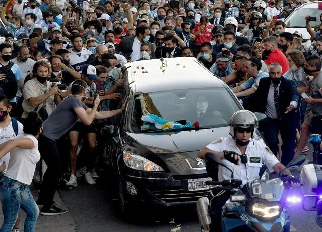  Photo released by Telam showing fans crowding next to the hearse carrying the late Argentine football legend Diego Armando Maradona while leaving Casa Rosada presidential palace to the cemetery, in Buenos Aires, on November 26, 2020. Argentine football legend Diego Maradona will be buried Thursday on the outskirts of Buenos Aires, a spokesman said. Maradona, who died of a heart attack Wednesday at the age of 60, will be laid to rest in the Jardin de Paz cemetery, where his parents were also buried, Sebastian Sanchi told AFP. (Photo by Raul Ferrari/TELAM/AFP Photo)