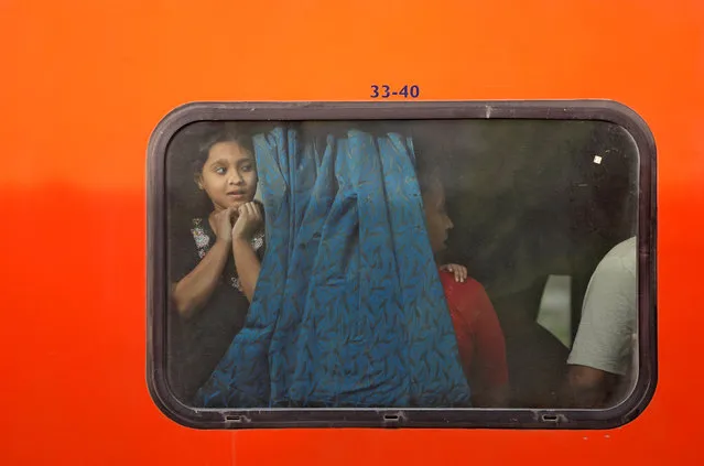 A girl looks through a window of a a train parked at a railway station in New Delhi, India, April 20, 2018. (Photo by Saumya Khandelwal/Reuters)